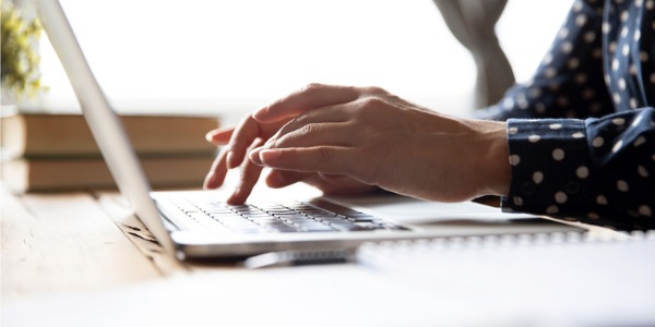 A screenwriter typing on her computer.