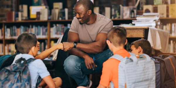 An outreach librarian talking to a group of kids.