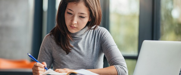 A technical writer sitting at a desk and going over written material.
