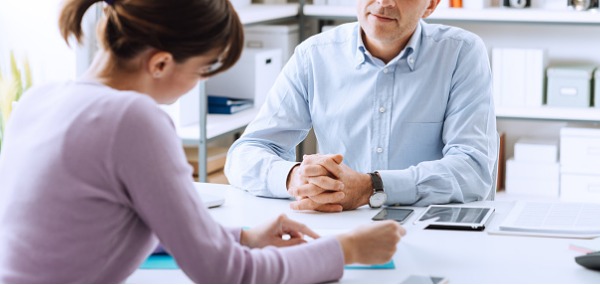 A genetic counselor sitting across a desk from a patient.