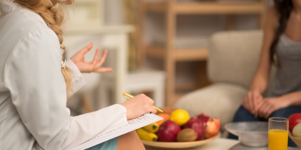 A health educator teaching a young woman how to incorporate positive and healthy habits into her life.