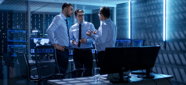 Three IT security consultants having a conversation in the office.